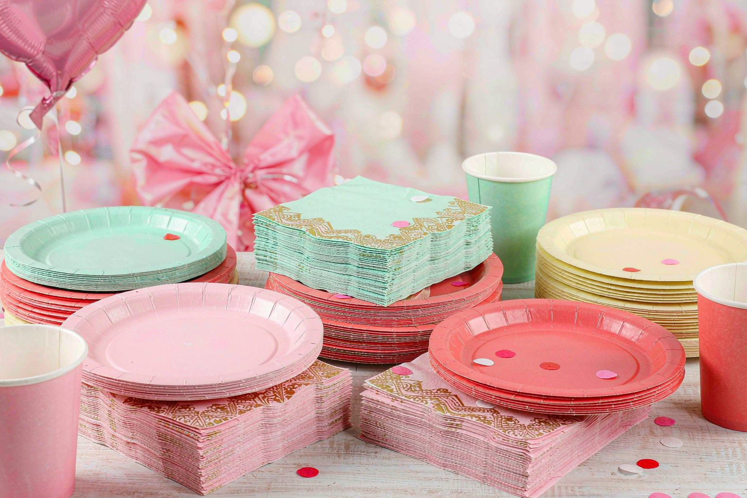 Printed party paper napkins with matching paper plates and cups on a festive table